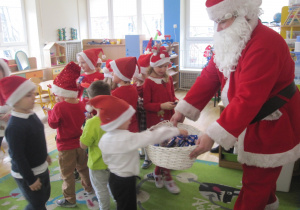 Dzieci z grupy IV częstują się czekoladkami od Mikołaja