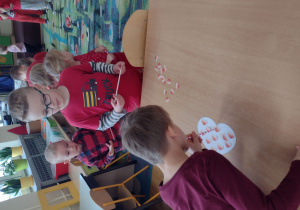 Chłopiec przekłada serduszka słomką