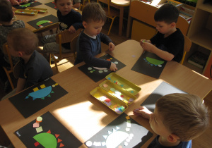 Maluszki wykonują dinozaury z figur geometrycznych