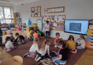 Dzieci wykonują szkielet dinozaura z rolek