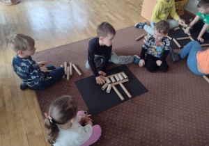 Dzieci wykonują szkielet dinozaura z rolek