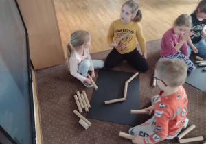 Dzieci wykonują szkielet dinozaura z rolek