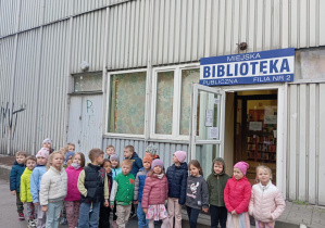 Dzieci stoją przed wejściem do biblioteki