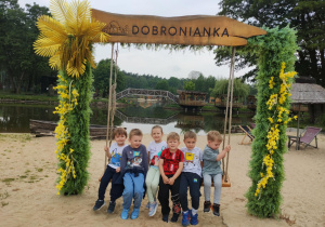 Dzieci siedzą na huśtawce z napisem Dobronianka