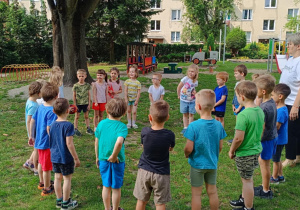 Dzieci podają sobie piłkę w kole