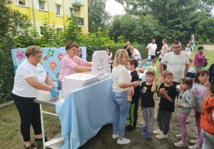 Dzieci ustawione w kolejkę po pizzę