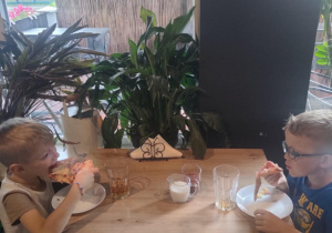 Dwóch chłopców je pizzę