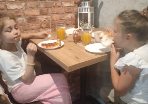 Dwie dziewczynki jedzą pizzę