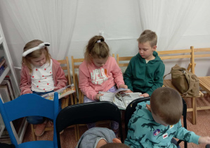 Dzieci oglądają książeczki w bibliotece