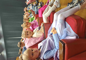 Dzieci siedzą w fotelach w teatrze