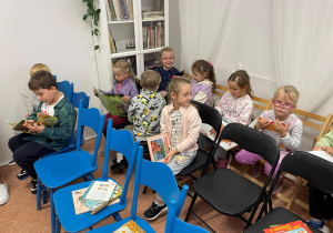 Dzieci przeglądaja książki biblioteczne