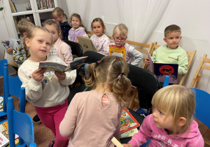 Dzieci przeglądaja książki biblioteczne