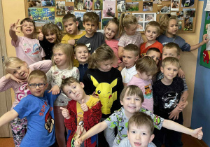 Dzieci z grupy IV przed tablicą ze zdjęciami zwierząt