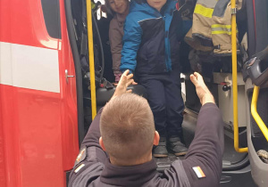 Chłopiec wychodzi z wozu strażackiego
