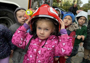 Dziewczynka przymierza kask strażacki