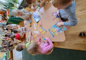 Dzieci z grupy III wycinają produkty z gazetek