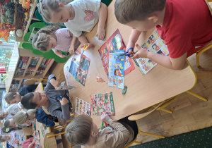 Dzieci z grupy III wycinają produkty z gazetek