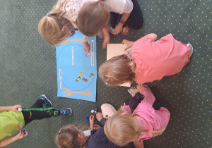 Dzieci z grupy III naklejają obrazki na rysunkowy talerz