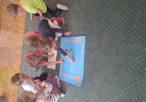 Dzieci z grupy III naklejają obrazki na rysunkowy talerz