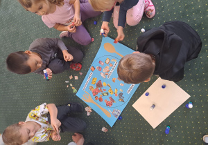 Dzieci z grupy III naklejają obrazki na rysunkowy talerz