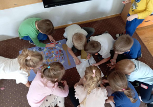 Dzieci z grupy IV naklejają obrazki na rysunkowy talerz