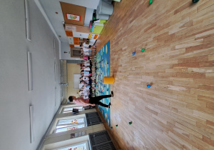 Dzieci oceniają, która piłeczka poleciała najbliżej żółtej pufy