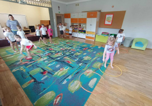 Dzieci z grupy IV podczas konkurencji przekładania ścieżki z hula hop