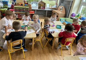 Dzieci z grupy II malują farbami rysunek kranu