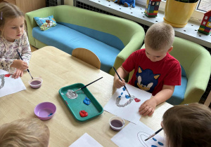 Dzieci z grupy II malują farbami rysunek kranu