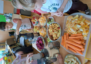 Dzieci z grupy III wybierają owoce i wkładają je do sokowirówki