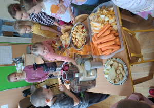 Dzieci z grupy III wybierają owoce i wkładają je do sokowirówki