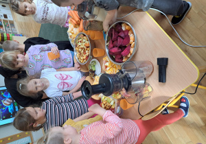 Dzieci z grupy III wybierają owoce i wkładają je do sokowirówki