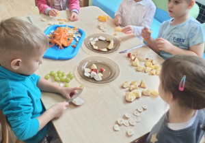 Dzieci z grupy II kroją owoce