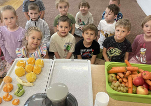 Dzieci z grupy IV czekają na dywanie, aby dodać gotowe owoce do sokowirówki