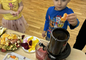 Chłopiec wrzuca sok do sokowirówki