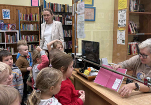 Dzieci uczą się jak wypożyczać książki z biblioteki