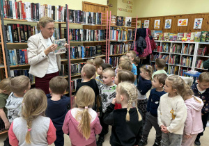 Dzieci oglądają zbiory książek w bibliotece