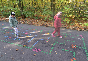 Dzieci przechodzą przez namalowany labirynt