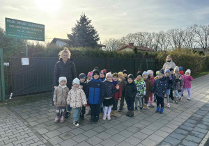 Dzieci stoją przed ogródkami działkowymi