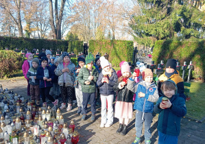 Dzieci stoją ze zniczami