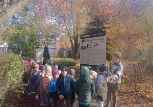 Dzieci stoją przy tablicy informacyjnej o Józefie Salwie