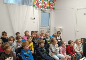 Dzieci słuchają bajki czytanej przez panią bibliotekarkę