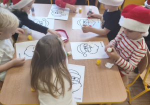 Dzieci z grupy I wykonują pracę plastyczną z Mikołajem