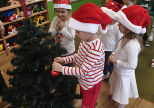 Dzieci z grupy I ubierają choinkę