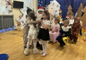 Dzieci przytulają Mikołaja