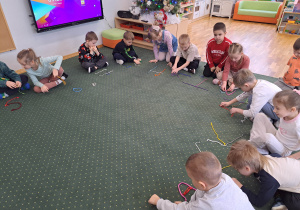 Dzieci układają litery ze sznurówek