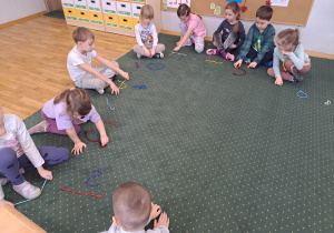 Dzieci układają litery ze sznurówek