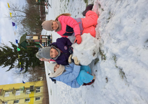 Trzy dziewczynki podczas budowania bałwana