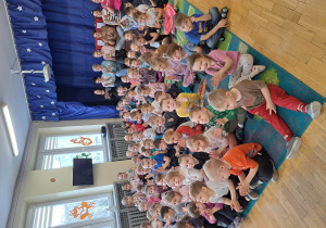 Dzieci klaszczą i śpiewają piosenkę razem z prowadzącymi