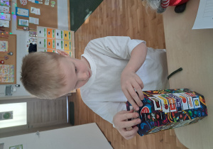 Chłopiec wrzuca pieniądze do puszki